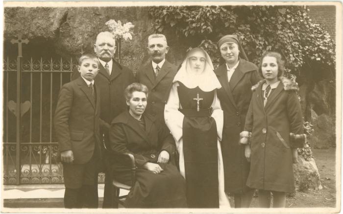 Familiefoto met kloosterzuster, 25 maart 1928