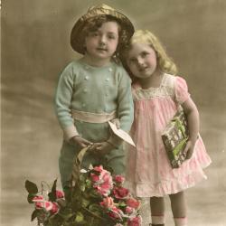 Beeldzijde kerst- en nieuwjaarskaart, jongen en meisje met korf bloemen