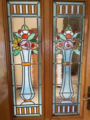 Twee glasramen met bloemenvaas in deur

