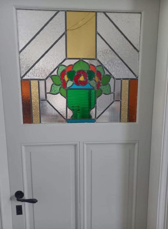 Rechthoekig glasraam met bloemmotief in deur