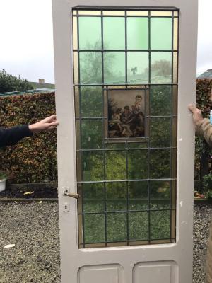 Rechthoekig glasraam met portret van Flor Coucke in deur