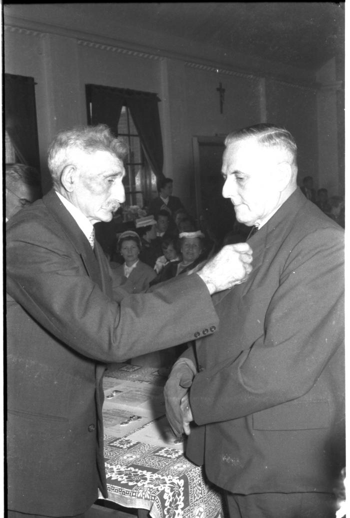 Huldiging gedecoreerden Unions: burgemeester speldt ereteken op bij Cyriel Windels, Izegem 1957