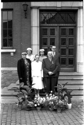 Huldiging gedecoreerden Unions: familie Windels poseert op stoep van stadhuis, Izegem 1957