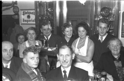 Kampioenviering café 'De Nieuwe Herder': feestvierders aan toog, Izegem 1957