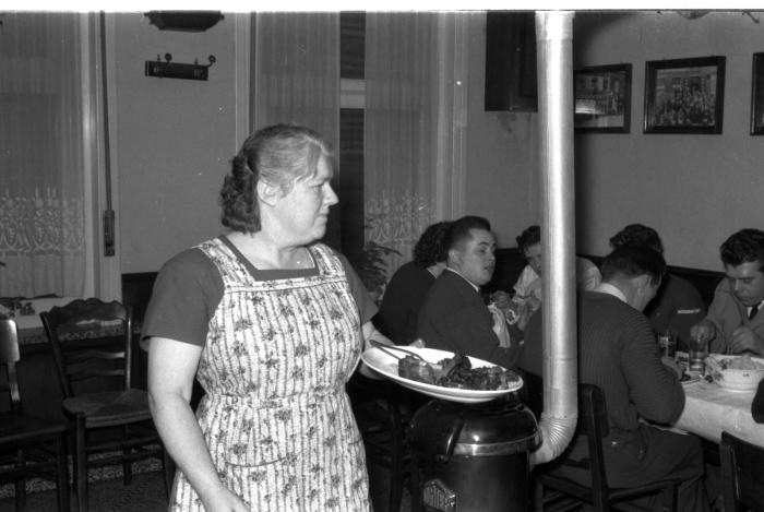 Kampioenviering boogschutters café 'Stad Kortrijk': feesttafel bij kachel, Izegem 1957